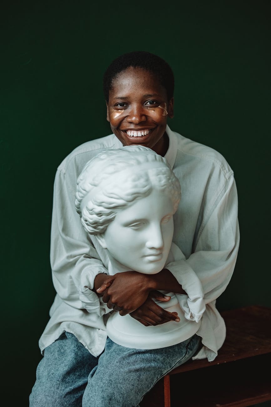 a woman with under eye masks holding a sculpture