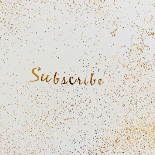 a word subscribe in gold color decorated with scattered glitters