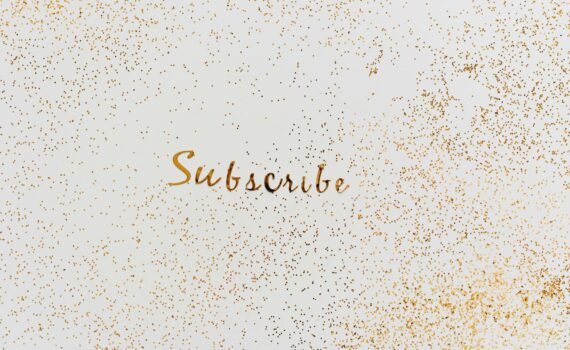 a word subscribe in gold color decorated with scattered glitters