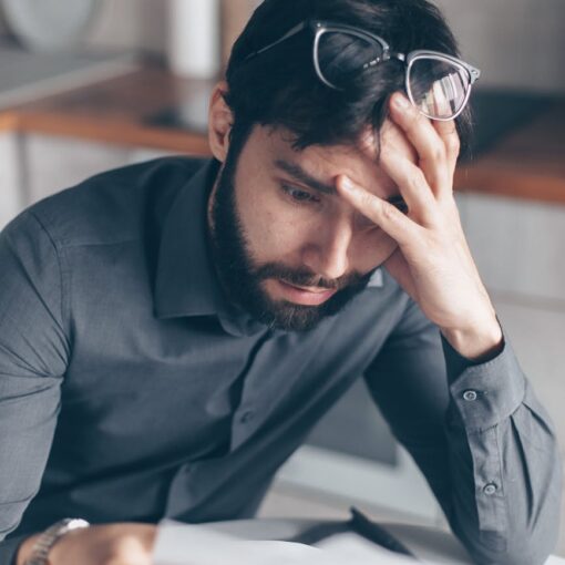 man in blue dress shirt with black framed eyeglasses feeling confused