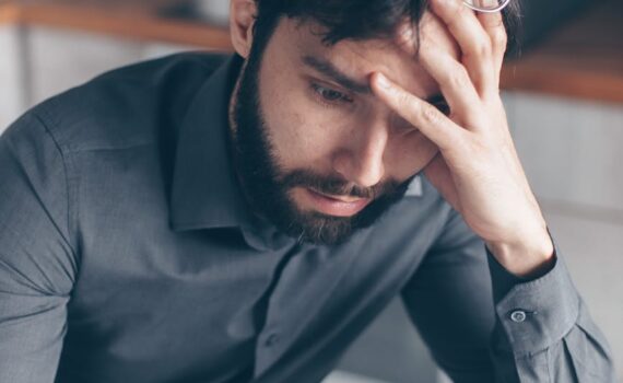 man in blue dress shirt with black framed eyeglasses feeling confused