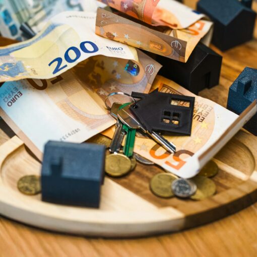 euro banknotes and keys with miniature houses