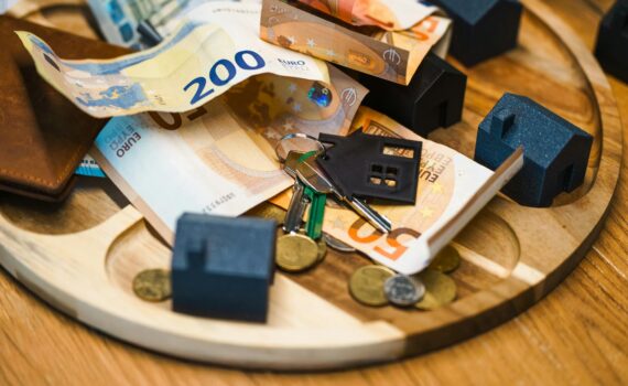 euro banknotes and keys with miniature houses